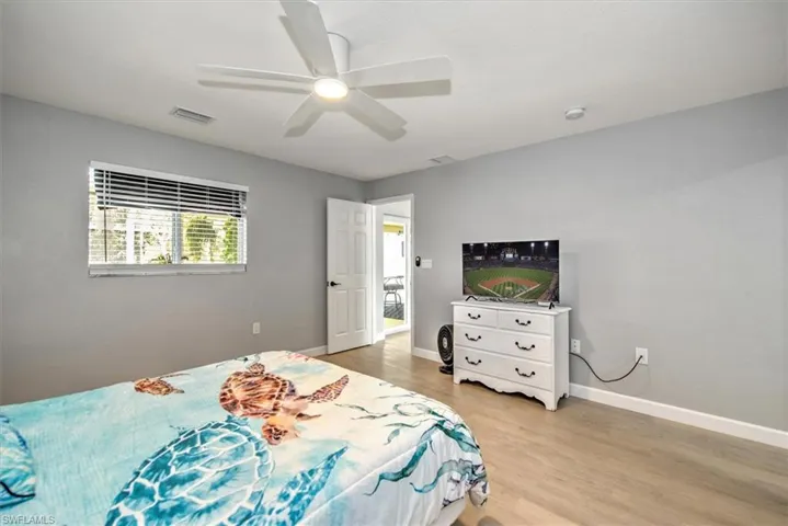 Bedroom featuring a ceiling fan, light wood-style flooring, baseboards, and visible vents