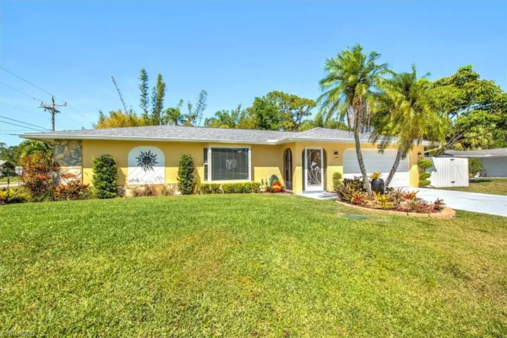 Single story home featuring a front lawn, concrete driveway, stucco siding, and an attached garage