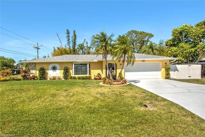Single story home with a front lawn, driveway, stucco siding, and an attached garage