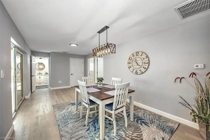 Dining room with an inviting chandelier, baseboards, light wood finished floors, and visible vents