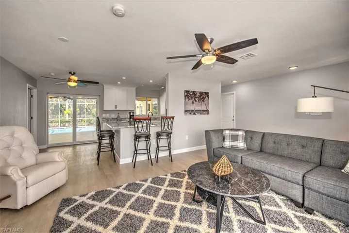 Living area with recessed lighting, baseboards, visible vents, light wood-style flooring, and ceiling fan