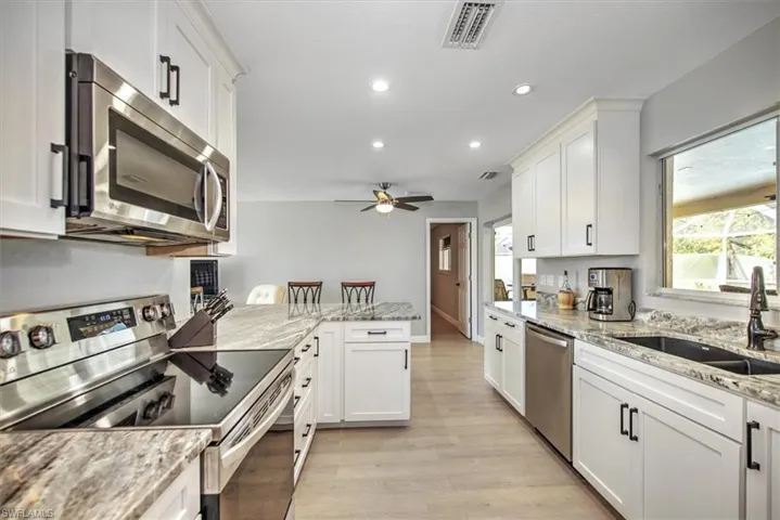 Kitchen with a sink, visible vents, appliances with stainless steel finishes, and white cabinetry