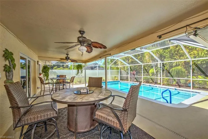 View of pool with ceiling fan, a lanai, and a patio area