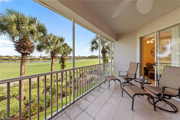 Balcony with ceiling fan, view of golf course, and a water view