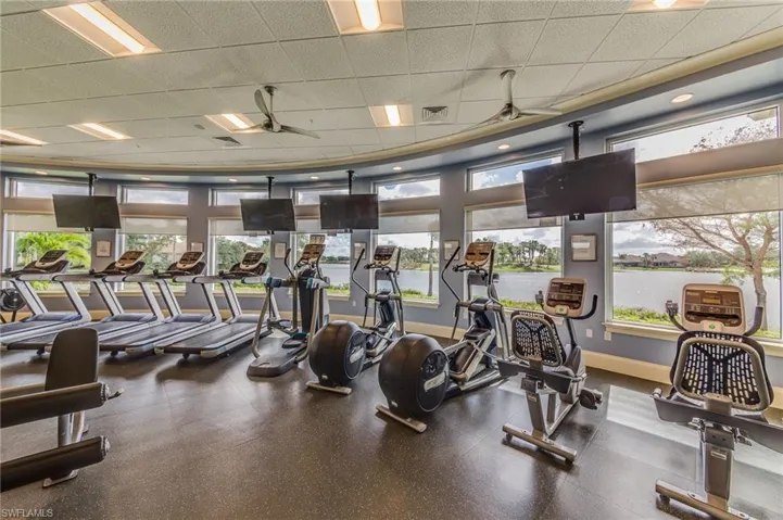 Workout area featuring ceiling fan and a drop ceiling