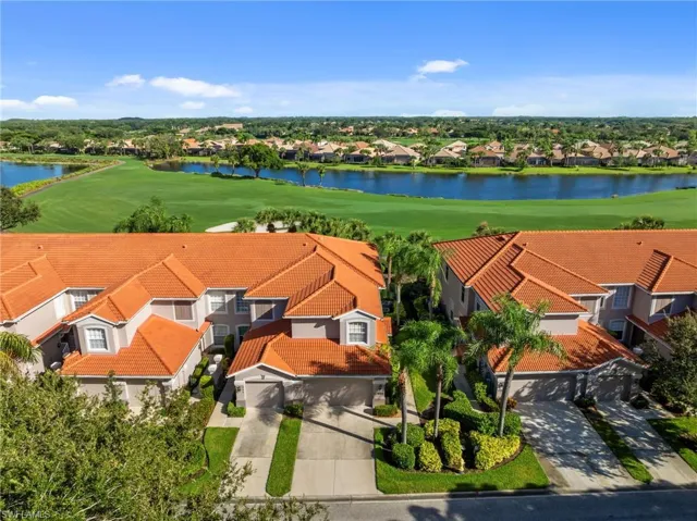 Aerial view of residential area featuring a golf club and a large body of water