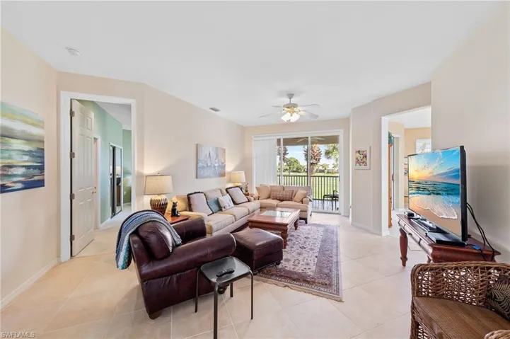 Living area with light tile patterned floors and a ceiling fan