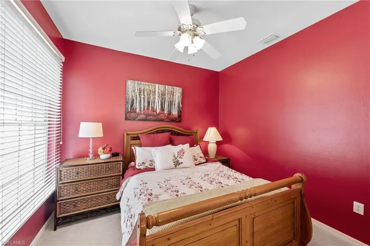Carpeted bedroom featuring ceiling fan and baseboards