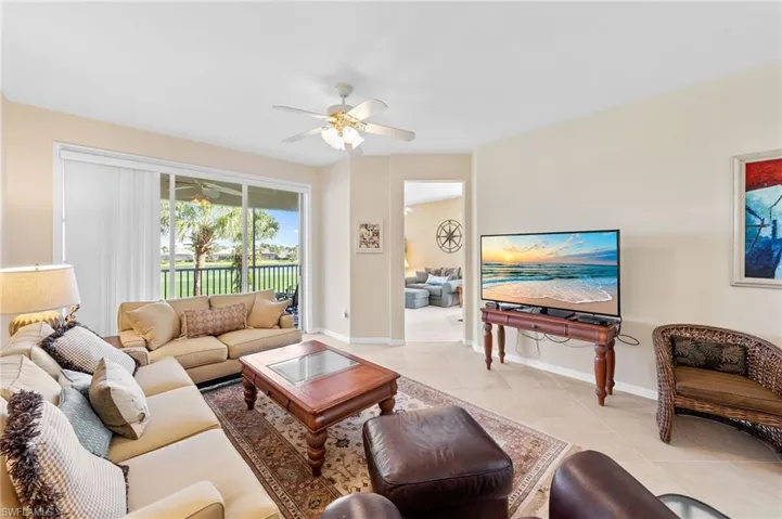 Living area featuring light tile patterned floors and a ceiling fan
