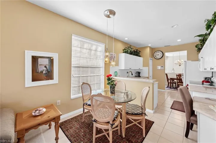 Dining room with light tile patterned floors, a chandelier, and recessed lighting