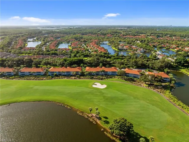 Aerial perspective of suburban area featuring a nearby body of water and a golf club