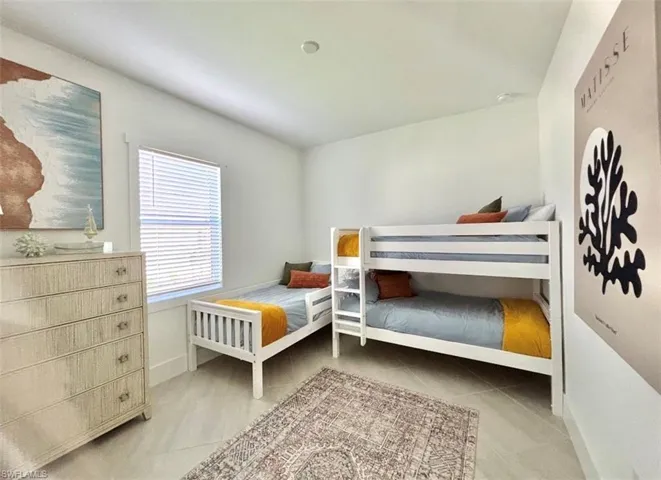 Bedroom with light tile patterned flooring and baseboards