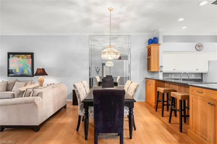 Dining space with a chandelier, crown molding, light wood finished floors, recessed lighting, and baseboards