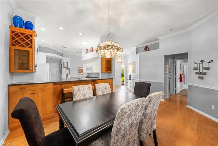 Dining area featuring crown molding, light wood-type flooring, a chandelier, recessed lighting, and baseboards