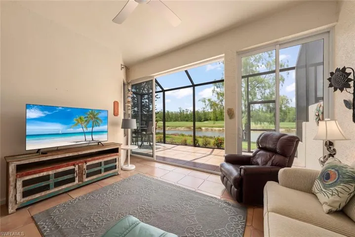 Living room featuring ceiling fan, a sunroom, and tile patterned floors
