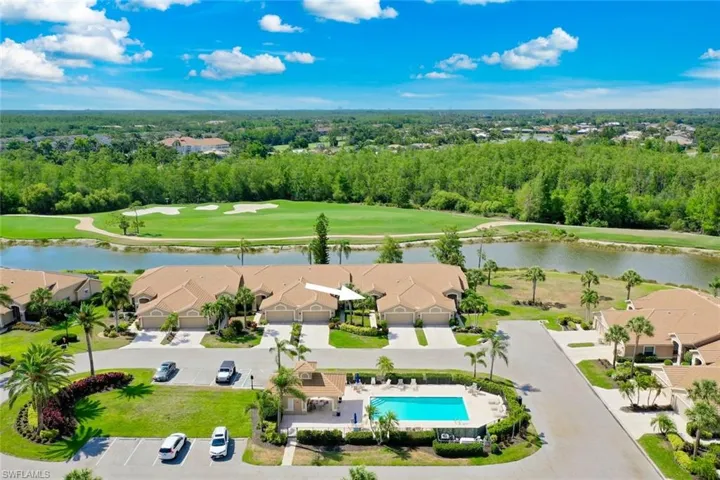 Right across  the street Aerial perspective of suburban area featuring a nearby body of water, a golf course, a pool, and a tree filled landscape