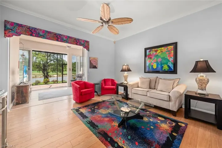 Living area with crown molding, ceiling fan, and wood finished floors