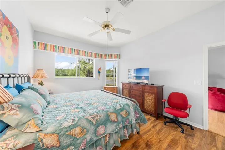 Bedroom with wood finished floors, a ceiling fan, and baseboards