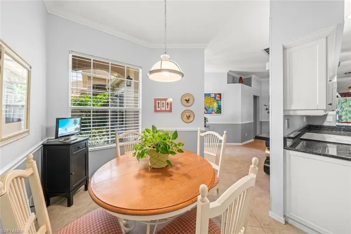 Dining area featuring light tile patterned flooring and ornamental molding