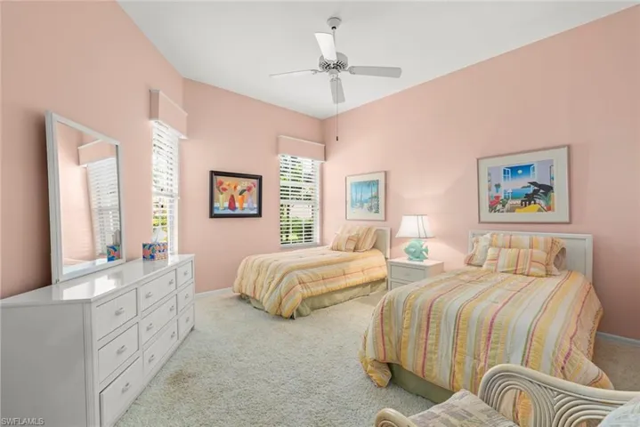 Bedroom featuring light carpet, baseboards, and a ceiling fan