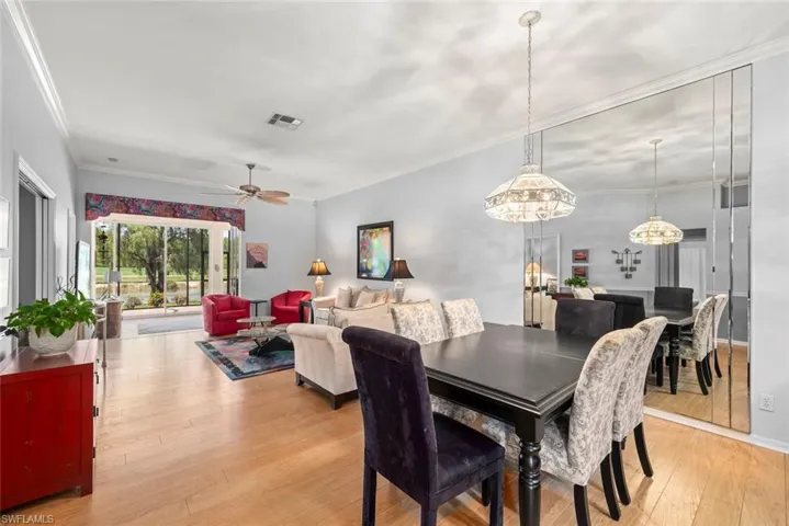 Dining space featuring light wood-style floors, ornamental molding, and a ceiling fan
