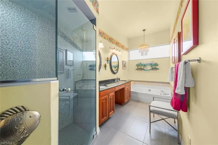 Bathroom featuring a stall shower, a bath, tile patterned floors, and double vanity