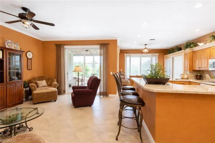 Kitchen featuring open floor plan, light stone counters, a breakfast bar area, healthy amount of natural light, and recessed lighting