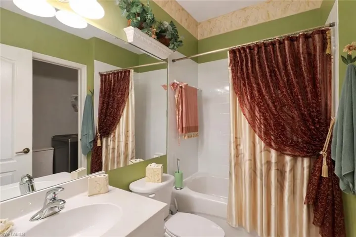 Bathroom featuring shower / bath combo with shower curtain and vanity