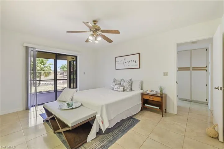 Bedroom featuring access to outside, light tile patterned floors, baseboards, and a ceiling fan
