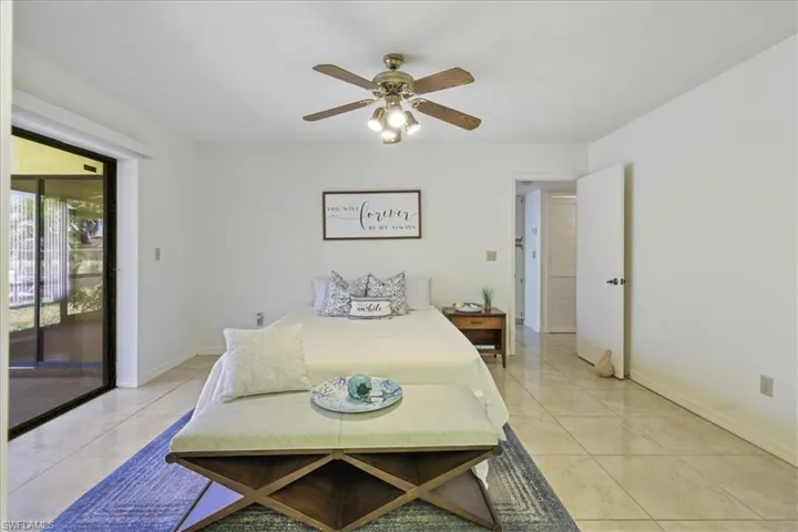 Bedroom featuring access to outside, baseboards, light tile patterned flooring, and a ceiling fan