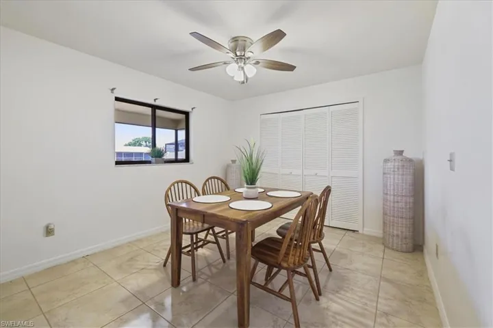 Dining space featuring a ceiling fan, baseboards, and light tile patterned flooring
