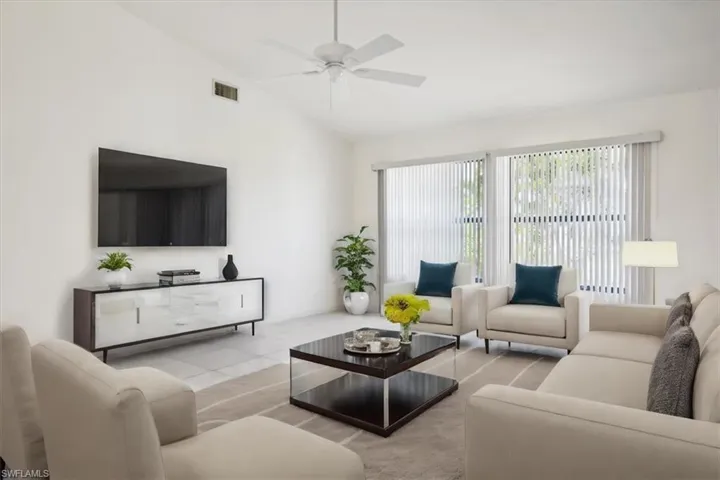 Living area featuring a ceiling fan and lofted ceiling