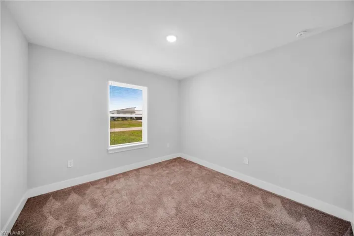 Neutral-toned walls complement the brown textured carpeting