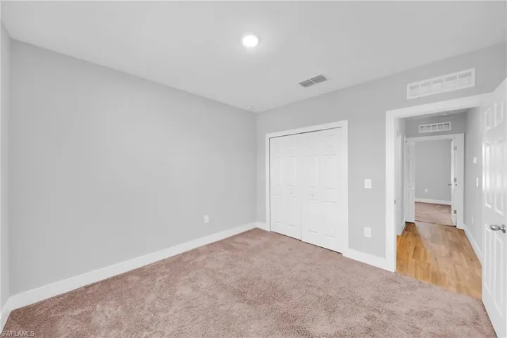 Carpeted room with a bi-fold closet, recessed lighting, and a neutral wall color