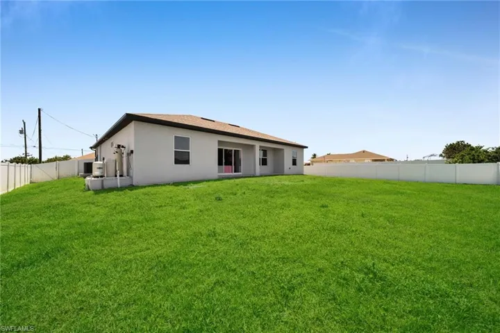 Expansive green lawn with a white vinyl fence encompassing the property