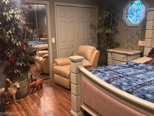 Bedroom with wood finished floors and a closet