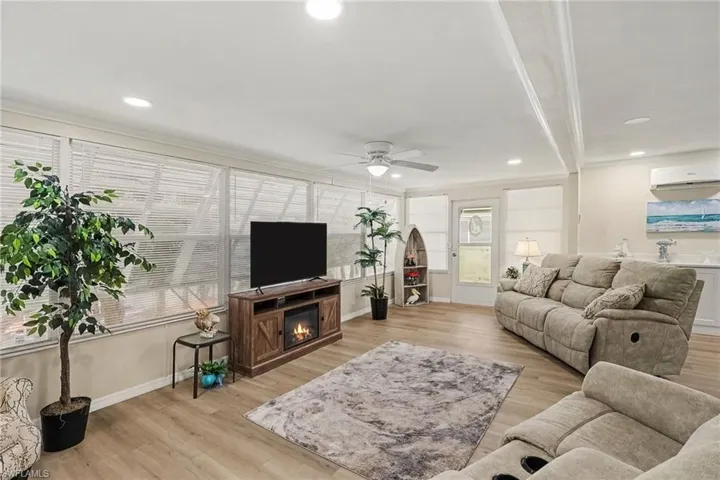 Recessed lighting, ceiling fan, built-in electric fireplace, and expansive windows