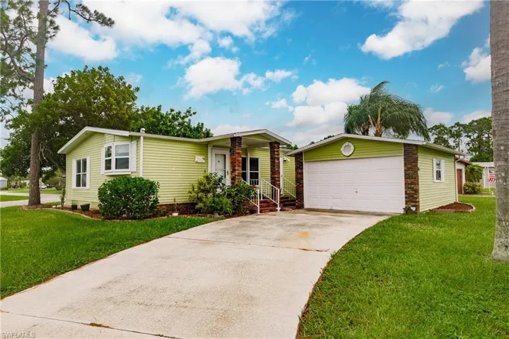 View of front of house with a garage and a front yard