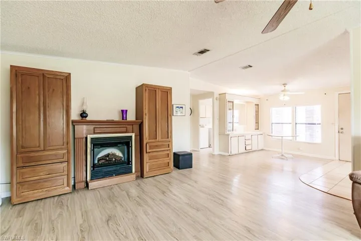 Unfurnished living room with light hardwood / wood-style floors, ceiling fan, and a multi sided fireplace