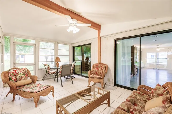 Sunroom featuring lofted ceiling with beams and ceiling fan