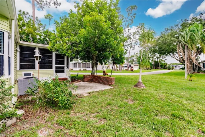 View of yard featuring a sunroom and central AC unit