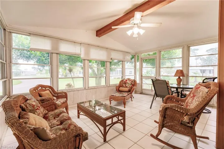 Sunroom / solarium with vaulted ceiling with beams and ceiling fan