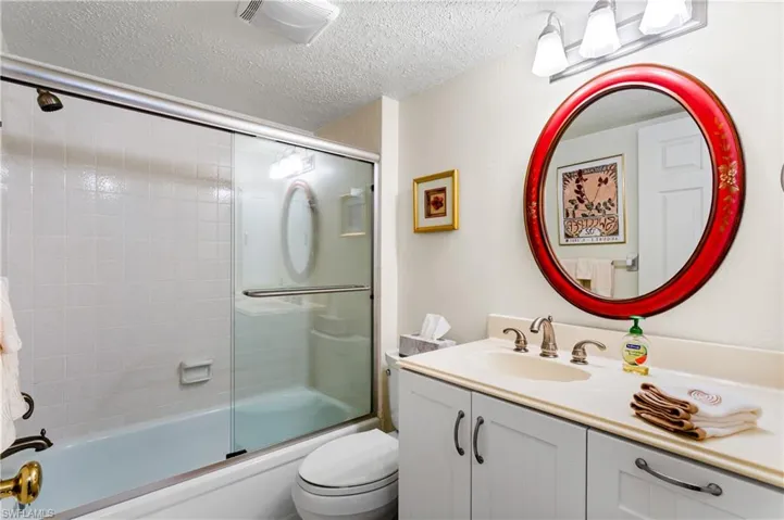 Guest bathroom with a tub/shower combination, newer glass shower door.