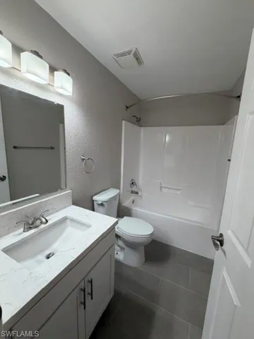 Bathroom featuring a white vanity with a rectangular undermount sink, a stone-finish countertop, and brushed nickel fixtures