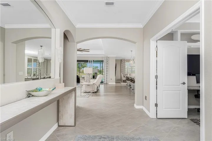 Corridor featuring crown molding, baseboards, and visible vents