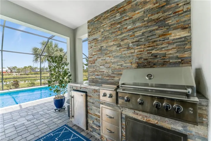 View of patio / terrace with a grill, an outdoor pool, glass enclosure, and area for grilling