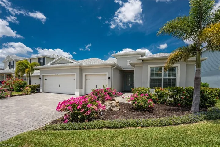 Prairie-style house with an attached garage, decorative driveway, and stucco siding