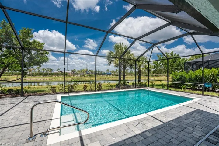 Pool with a lanai, a patio, and a water view