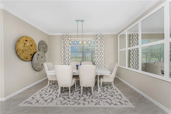 Dining room with baseboards, ornamental molding, and a chandelier