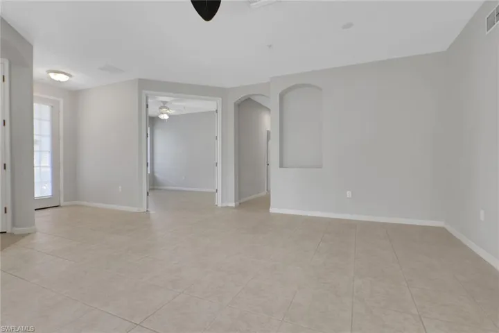 Living room with view of den and front door
